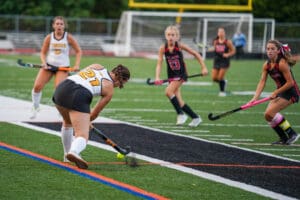 Field hockey players in action during a competitive match, focusing on strategy and teamwork on the field.
