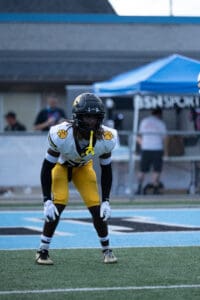 Football player in yellow and black gear ready for action on the field.