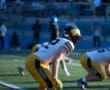 Football player in yellow Tigers uniform on field, ready to play during a game.