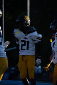 Football player wearing number 21 jersey in action under stadium lights.