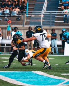 Football players in action during a high school game with a tackle on the field.