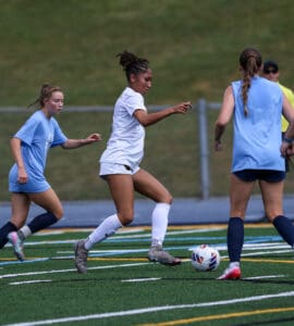 Soccer players compete for the ball on a field, showcasing agility and teamwork during an intense match.