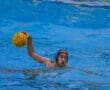 Water polo player ready to throw the ball in pool during a match.