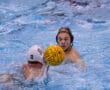 Water polo match action with two players competing for possession in a swimming pool.