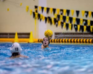Water polo player preparing to throw a ball during a competitive pool match.