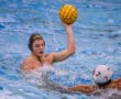 Water polo players in action, one preparing to throw the ball.