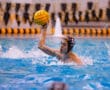 Water polo player in action, preparing to throw the ball during a competitive pool match.