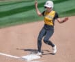 Softball player sliding into base during a game in sunny weather.