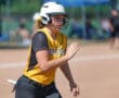 Softball player in yellow jersey running on the field during a game, wearing a helmet and focused on the action.