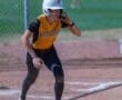 Softball player preparing to run at a base wearing a yellow North Allegheny jersey and helmet.
