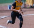 Softball player in action, wearing a helmet and North Allegheny jersey, sprinting on a dirt field.