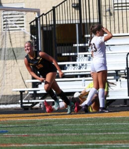Soccer player celebrating a goal with teammates on the field, showing excitement and energy during a match.