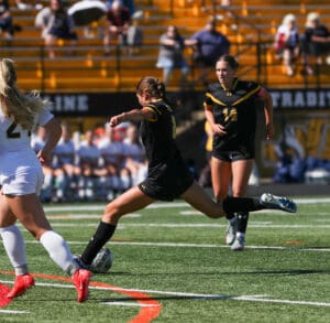 Soccer players in action during a match on a sunny day, focusing on teamwork and strategy.