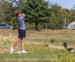 Golfer in mid-swing on a sunny course, showcasing focus and athleticism in a natural setting.
