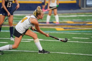 Field hockey player in action on the field, preparing to hit the ball with focus and determination.
