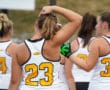 Women athletes in numbered jerseys at a sports event, preparing to play, focusing on team spirit and competition.