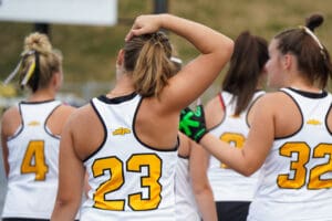 Women athletes in numbered jerseys at a sports event, preparing to play, focusing on team spirit and competition.