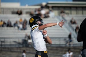 Football player practicing throws on the field during a sunny day game.