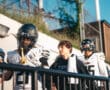 Football players in uniform walking onto the field, preparing for a game, sunny day.