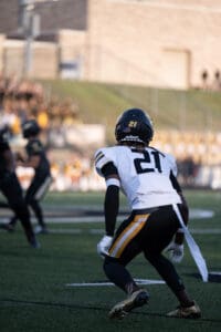 Football player in action on the field, wearing a number 21 jersey, ready for play.