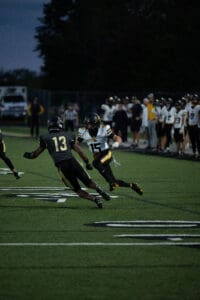 Football players in action on the field during a night game.
