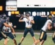 Football quarterback preparing to throw during a night game at Gateway Stadium.