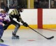 Roller hockey players in action on the rink, wearing colorful gear and focused on the puck.
