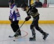 Inline hockey players in action on rink, focused on puck control and speed.