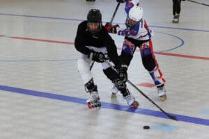 Inline hockey players in action on a rink, competing for the puck with intensity and skill.
