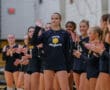 Volleyball player being introduced, surrounded by applauding teammates, wearing a North Allegheny jersey.