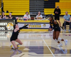 Volleyball players in action during a competitive match at North Allegheny school gymnasium.