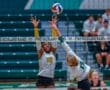 Two volleyball players in action at the net during a match at Pine-Richland Rams gym.