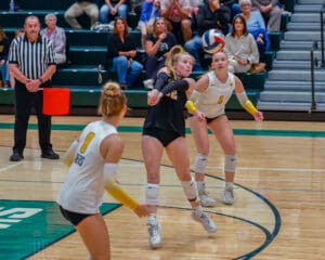 Volleyball player in action, focusing on a powerful bump during a competitive indoor match.