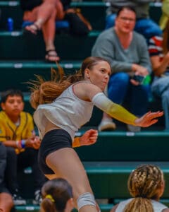 Female volleyball player in action, preparing to spike the ball during an intense indoor match.