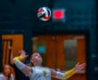 Volleyball player in action, preparing to serve during an intense indoor game.