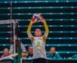 Volleyball player number 6 sets the ball during a match indoors, wearing a yellow and white uniform.