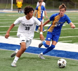 Two soccer players compete passionately on the field during a match.