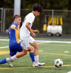 Two soccer players in action on a field, competing for the ball during a match.