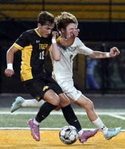 Two soccer players in action, competing for possession during a match on a vibrant field.