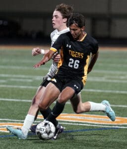 Two soccer players competing intensely for the ball on a field during a match.