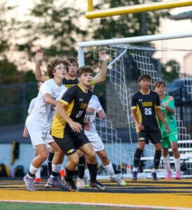 High school soccer players in action near the goal during an intense match, focused and ready to play.