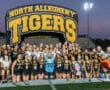 North Allegheny Tigers field hockey team group photo on the field under stadium lights.
