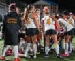 North Allegheny field hockey team huddles on the field, preparing for the game at night.