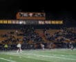 Field hockey match under lights, with spectators on bleachers and players in action, at North Allegheny stadium.