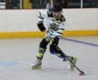 Inline hockey player in action, focused on controlling the puck indoors, wearing North Hockey gear.
