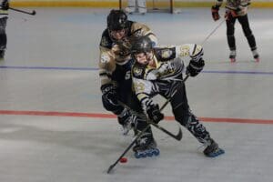 Inline hockey players compete for the puck during a fast-paced match on the rink. Racing, competition, sports action.