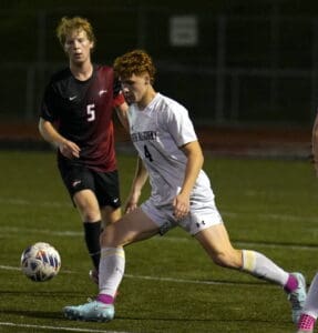 Soccer players in action on the field during a competitive night match.