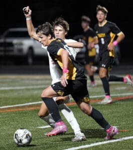 Soccer players compete for the ball on a field during a match, showcasing intense action and teamwork.