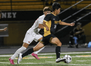 Soccer player dribbles past opponent during a night match.