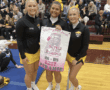 Three cheerleaders holding a banner for Best Pyramid at a cheer competition, celebrating their victory.
